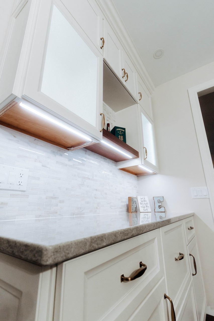 undercabinet lighting illuminating a white marble countertop in a luxury kitchen