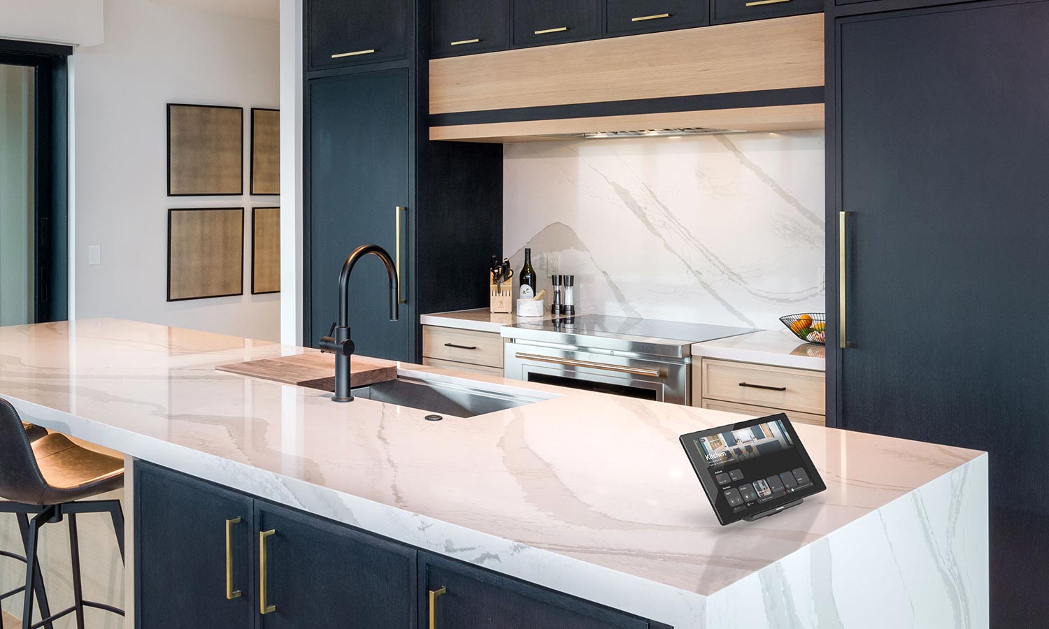 Contemporary kitchen with smart home control tablet on marble island