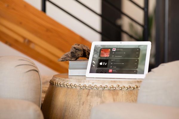 Tablet on a round table showing a home control interface in a living space